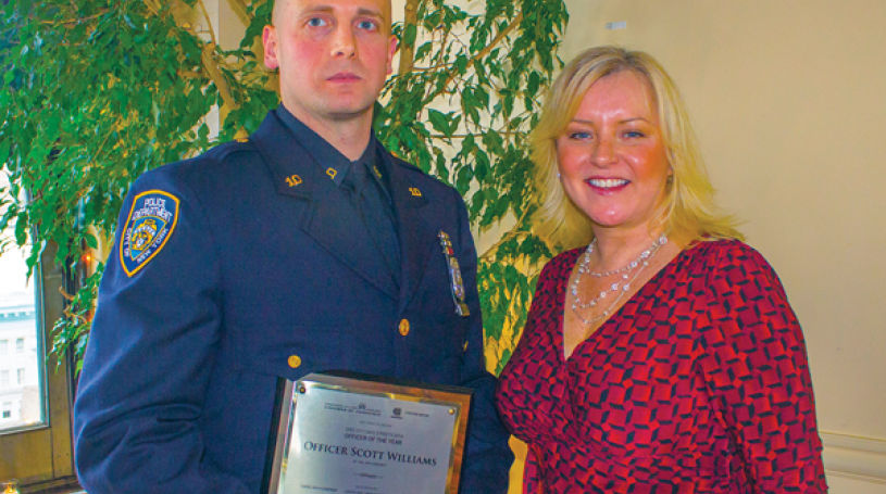 Photo by Zach Williams NYC Community Media publisher Jennifer Goodstein, with NYPD Officer Scott Williams of the 10th Precinct (holding his Officer of the Year award). Williams played a key role in the arrest of two foreign nationals who were using the identities of 53 different individuals to withdraw money from local ATMs.