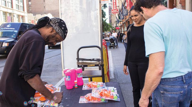 Street vendor Tony Fisher, a fixture on Sixth Ave., has often thought of the Twin Towers since Sept. 17’s bombing. Photo by Naeisha Rose.